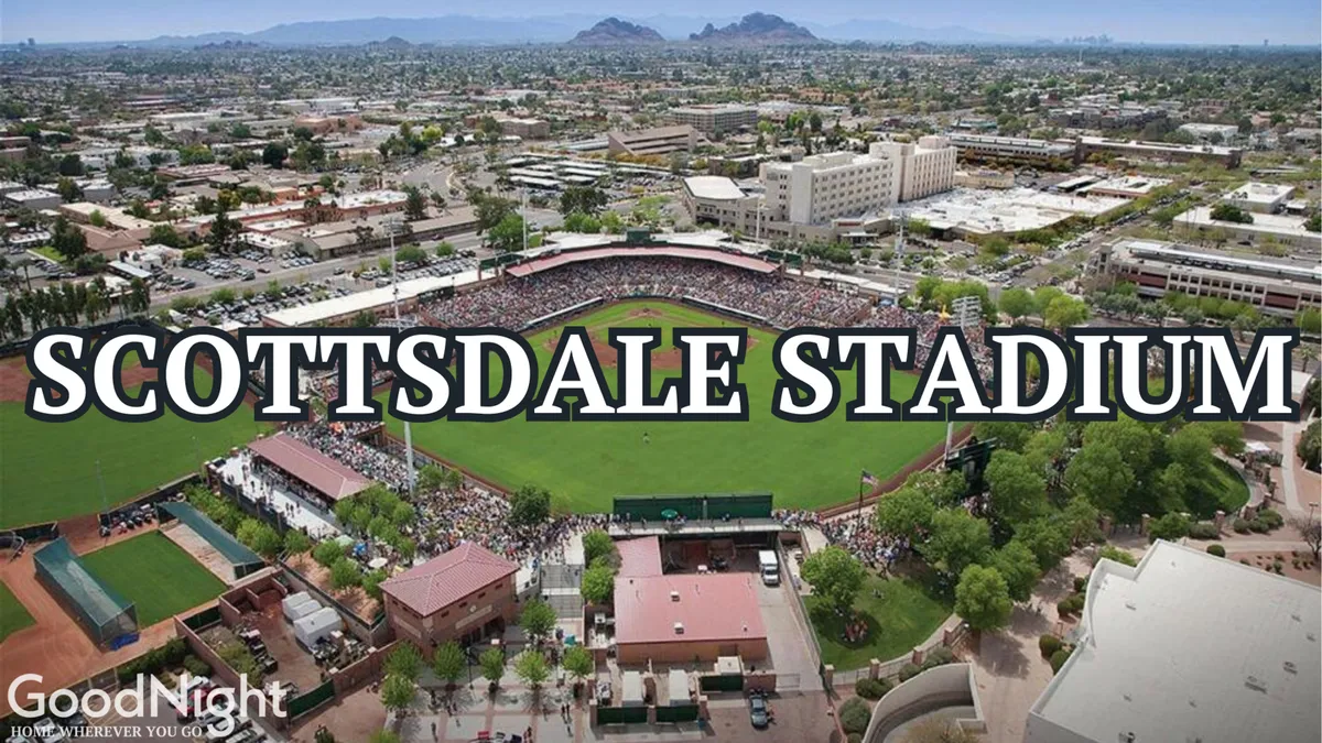 An energetic exterior scene at Scottsdale Stadium, bustling with a crowd enjoying a baseball game. The view includes the lively field, surrounding buildings, and the vibrant atmosphere of downtown Scottsdale.